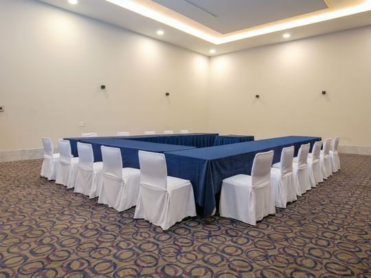 Diego Rivera event room at Camino Real Guadalajara in Zapopan, featuring carpeted floor, blue tables, and white chairs