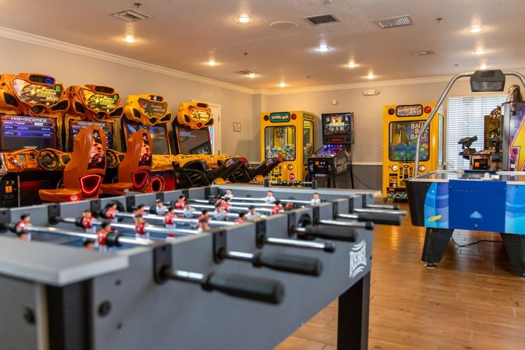Game room with foosball table and arcade games including racing simulators at Legacy Vacation Resorts