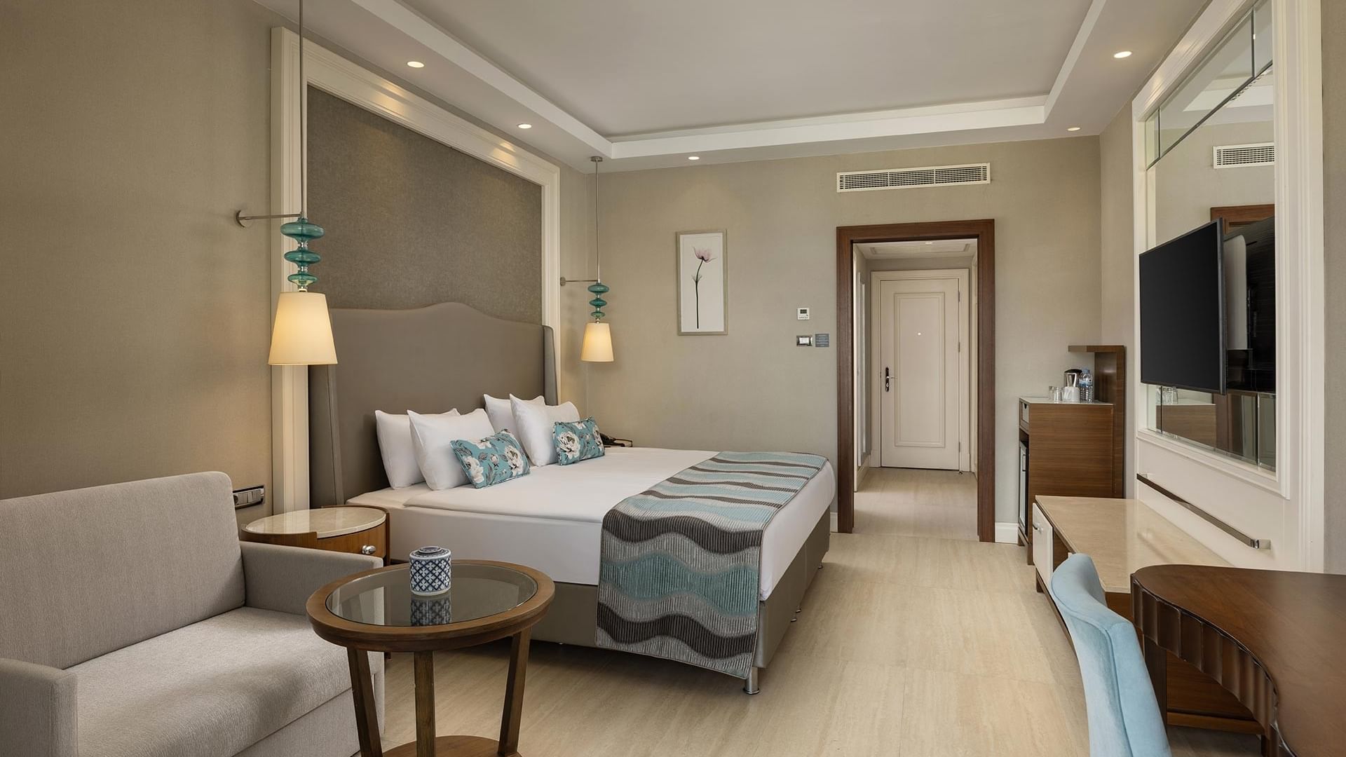 Standard Room with a bed, couch, table, and TV at Titanic Deluxe Golf Belek in Antalya.