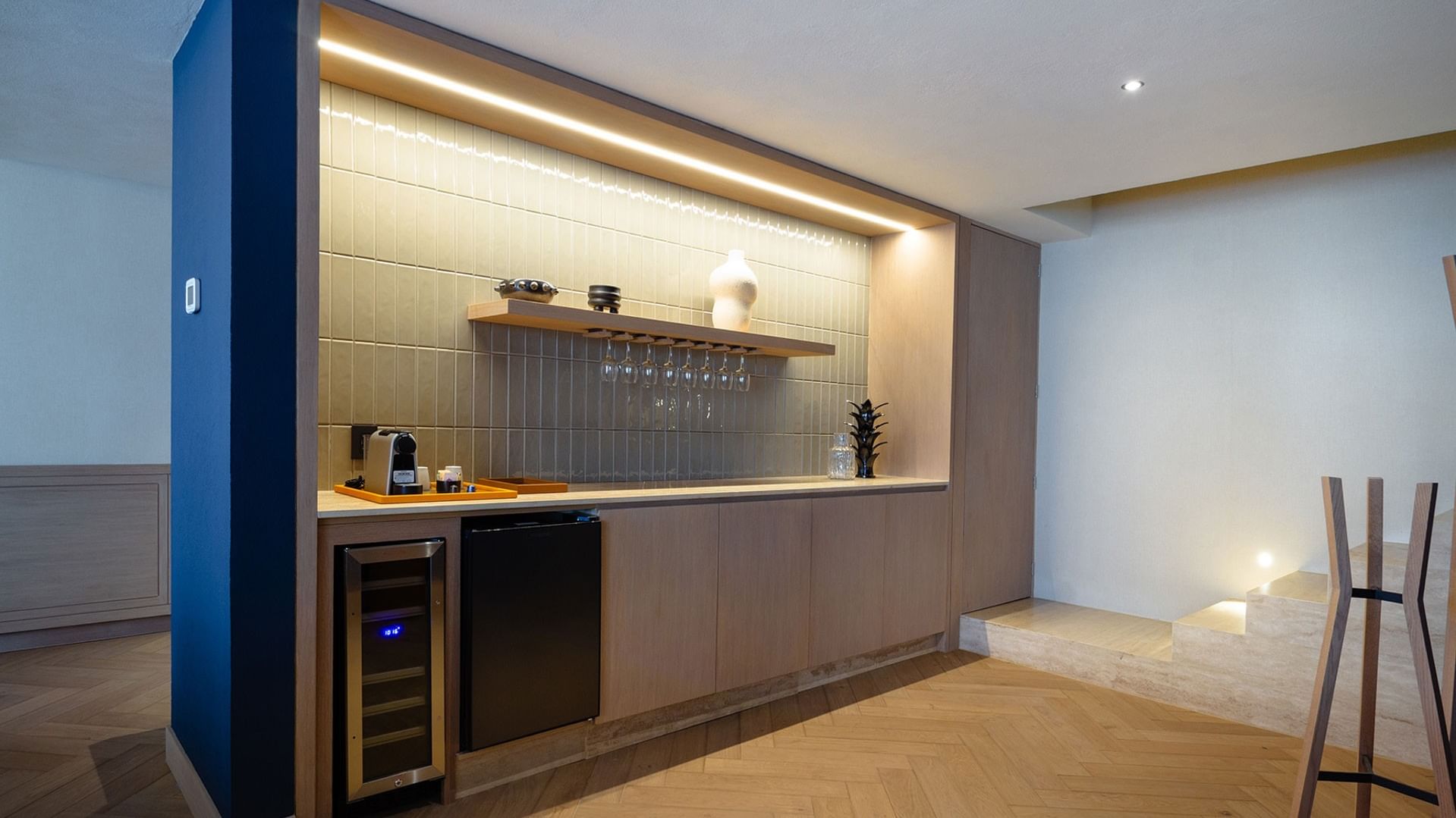 King Superior Viceroys Suite wet bar featuring a wine cooler, glassware, and ambient lighting at Camino Real Polanco Mexico