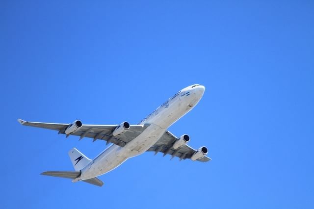 An airplane is flying a clear blue sky near Lake Buena Vista Resort Village & Spa