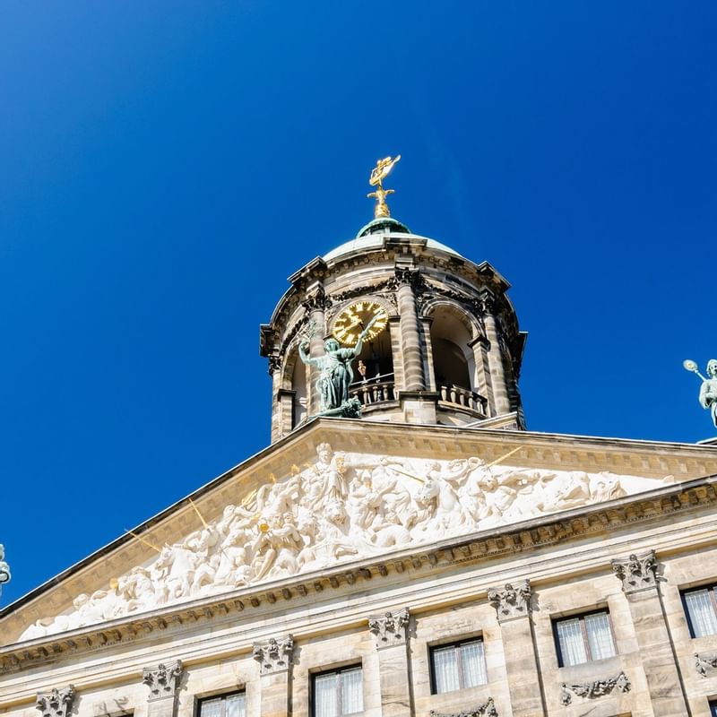 Architectural detail of the building with ornate statues in Dam Square near Luxury Suites Amsterdam