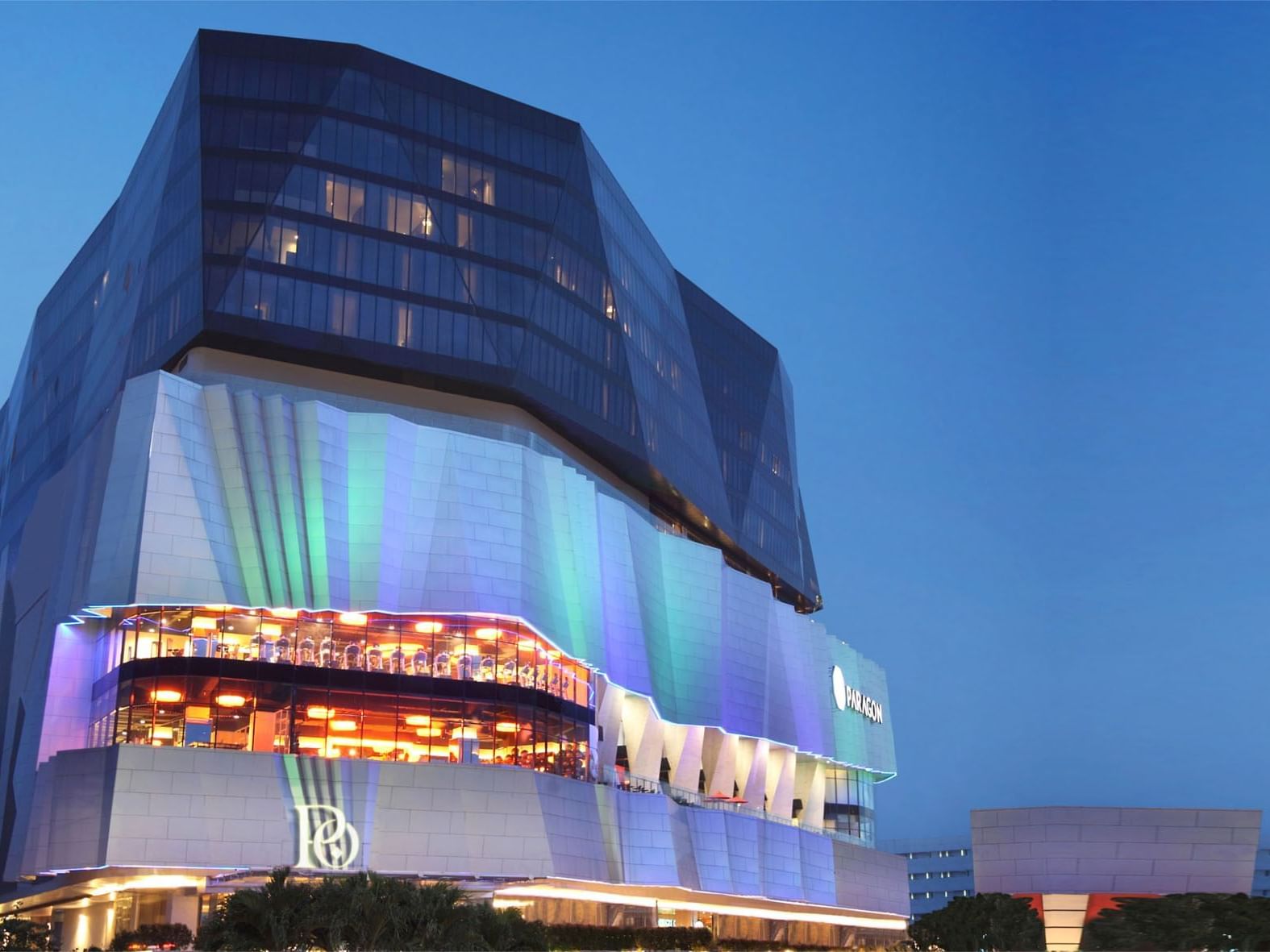 Low-angle view of illuminated Po Hotel Semarang under the evening sky