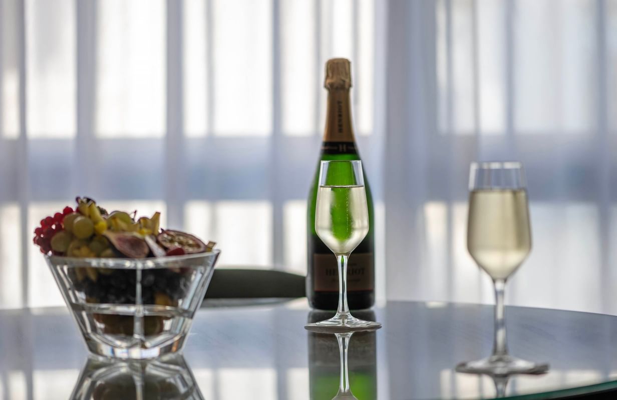Champagne bottle and filled glasses next to a fruit bowl at the Warwick Reine Astrid - Lyon
