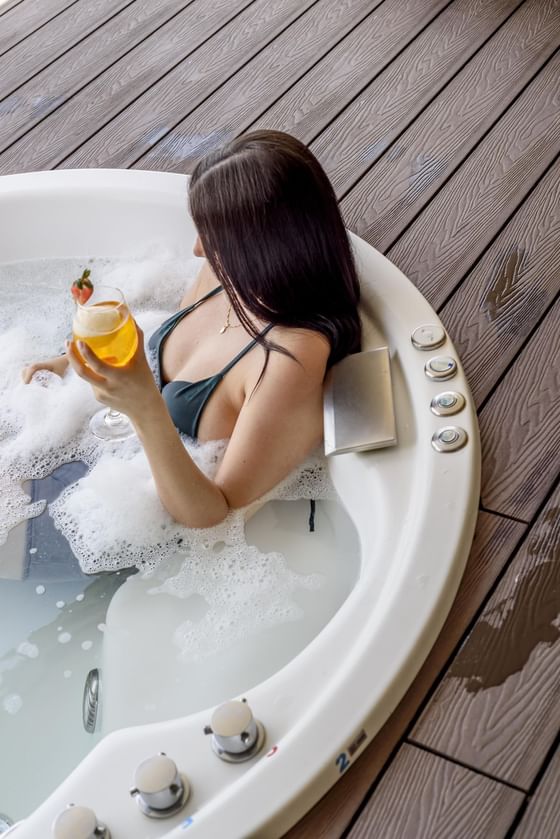 A woman enjoying a soak in a hot tub at Diez Hotel Categoría