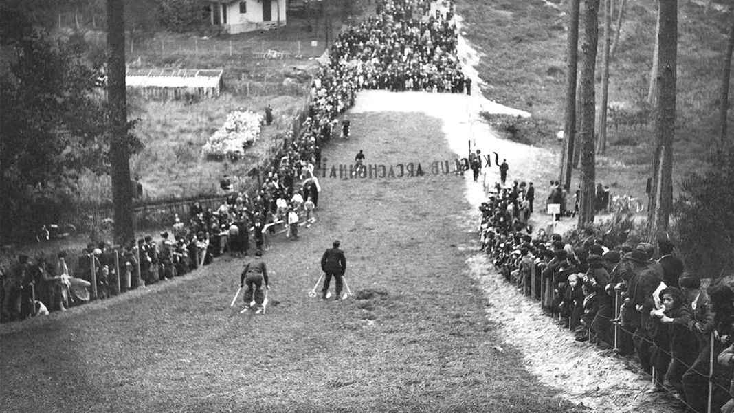 Image en noir et blanc d'un groupe de personnes debout sur une colline herbeuse près des Hôtels Oceania