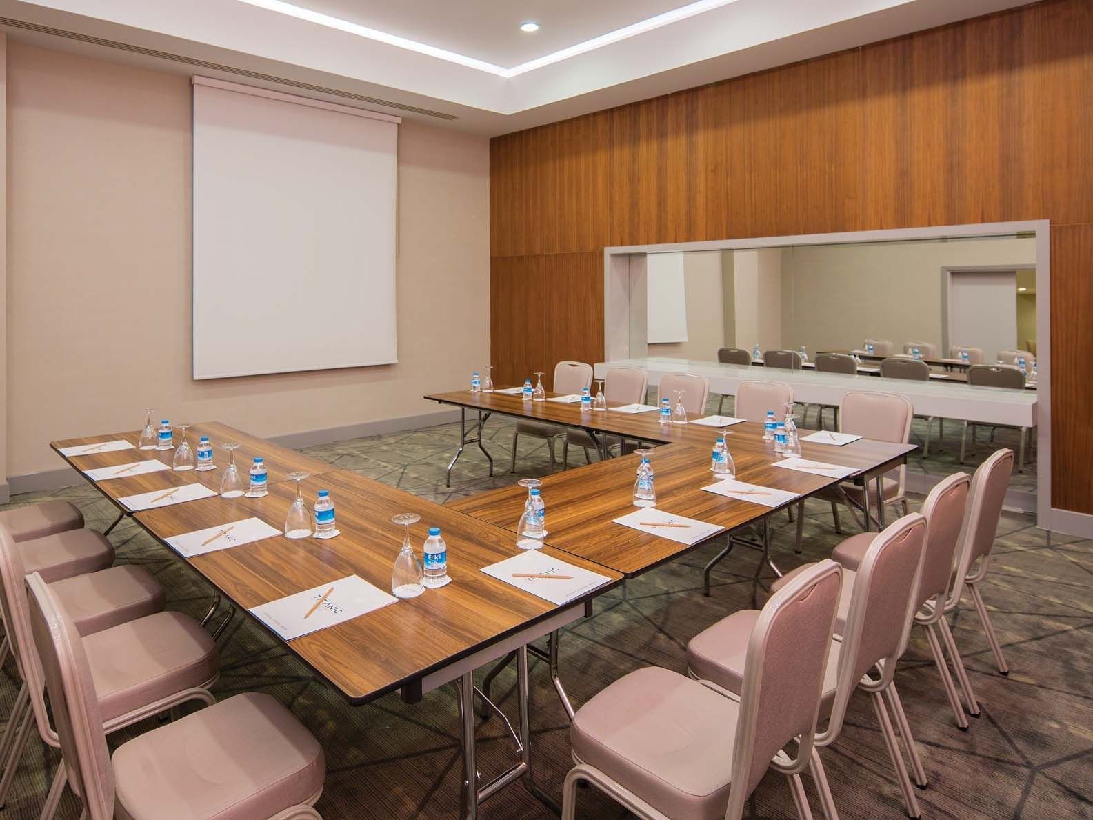 U-shaped meeting table arranged with chairs and a large screen in Black Sea Meeting Hall at Titanic Deluxe Lara