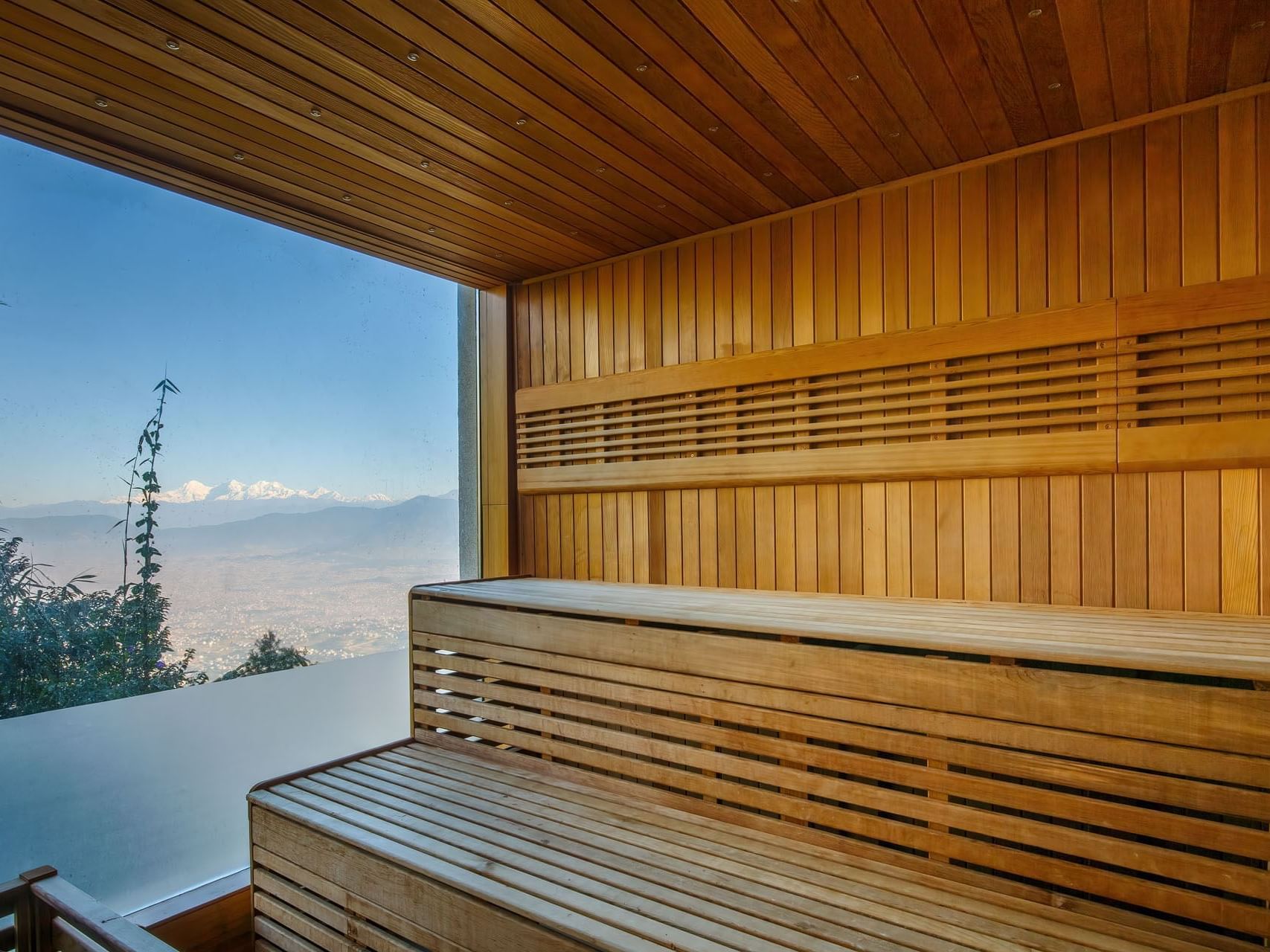 Wooden sauna interior with large window overlooking mountains at The Terraces Resort & Spa