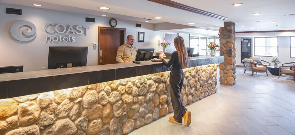 A person checks in at a hotel in Canmore, excited for their stay during peak season.