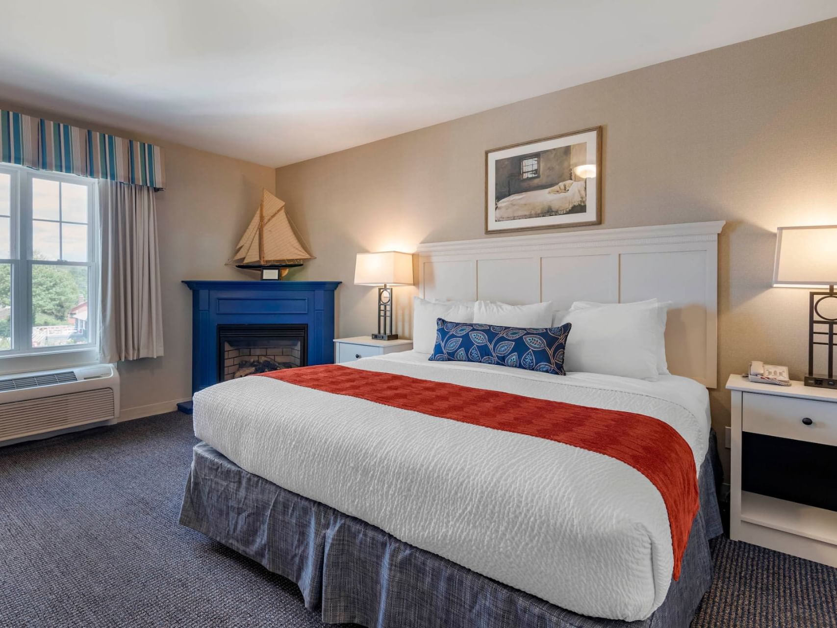 Cozy bed and nightstands in Harbor Village Admiral Suite at Sebasco Harbor Resort by Ogunquit Collection