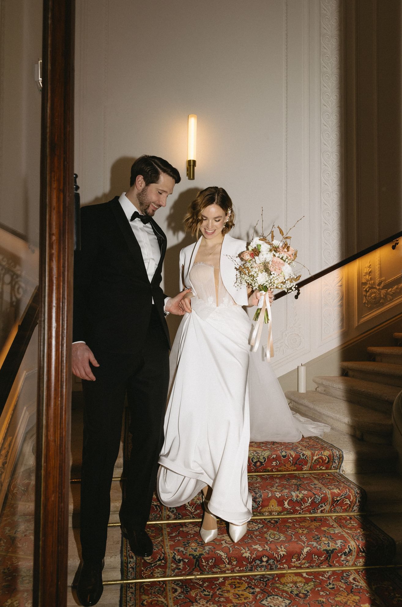 Newlywed couple descending stairs in their wedding at Almanac Palais Vienna