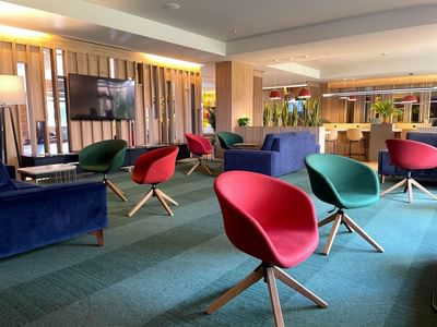 Lounge area with plush seating and a green carpet at Habitel Prime Hotel, one of the top hotels near Bogota airport