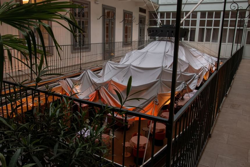 Innenhof mit überdachtem Zelt, Metallgeländern und grünen Pflanzen bei The Leo Grand