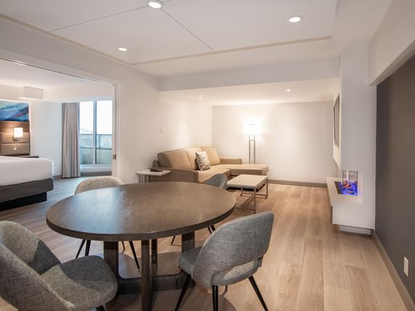 Living room with couch, table, and dining set in Coast Premium King One Bedroom Suite at Coast Bastion Hotel in Nanaimo.
