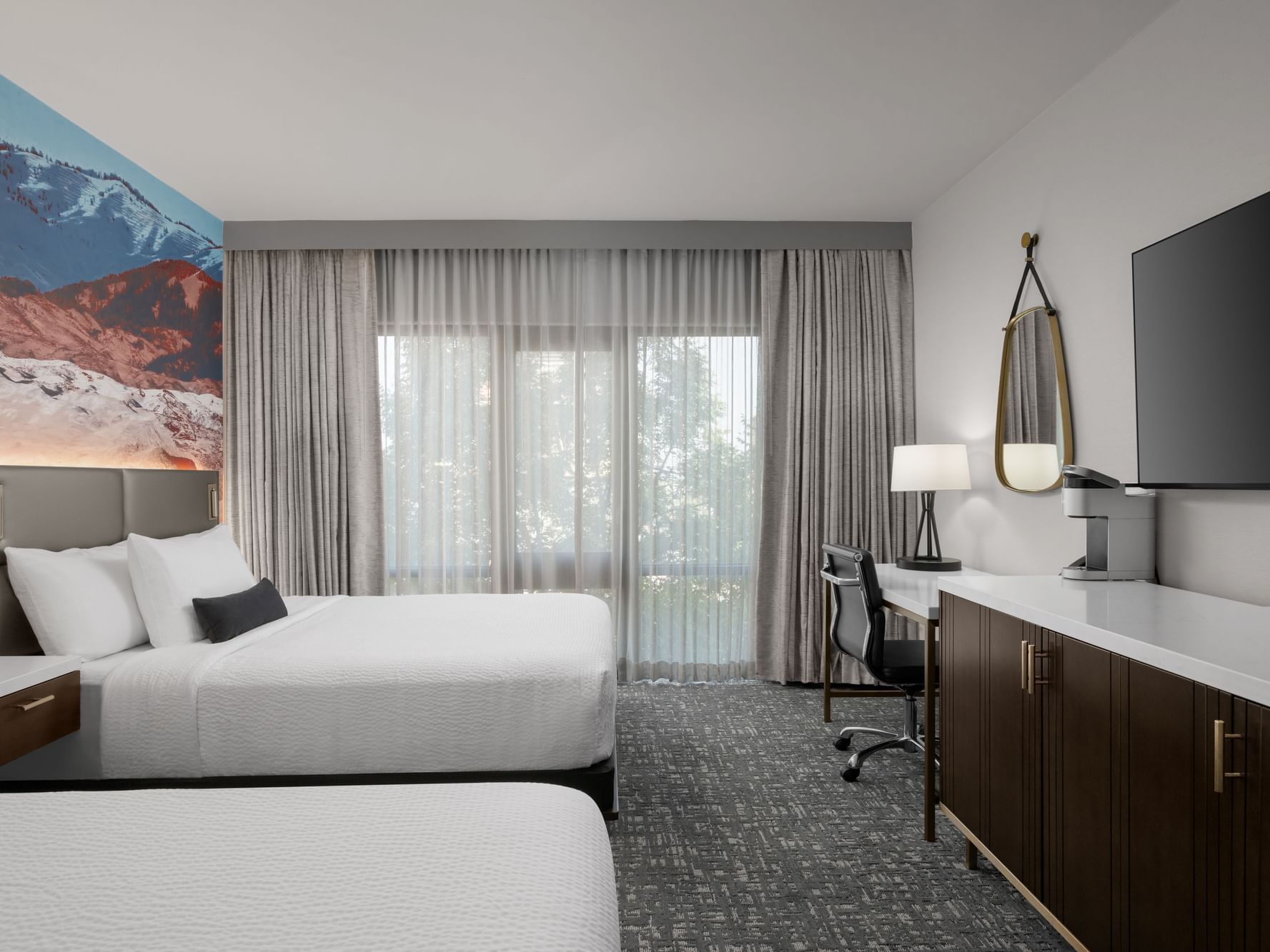 Two beds facing TV and workspace in Capitol Double Queen at Hotel 43