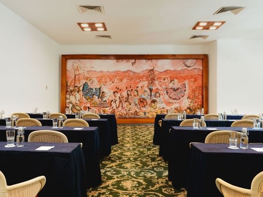 Classroom set-up in Indato II with carpeted floors and a vibrant mural on the wall at Camino Real Zaashila Huatulco