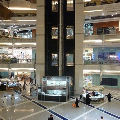Wide interior view of Abraj Al-Bait Mall with glass elevators and boutiques near Saja by Warwick Makkah