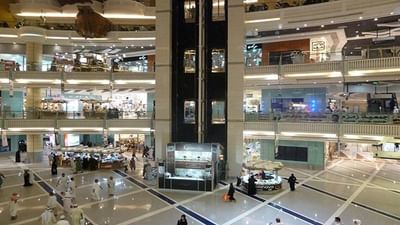 Wide interior view of Abraj Al-Bait Mall with glass elevators and boutiques near Saja by Warwick Makkah