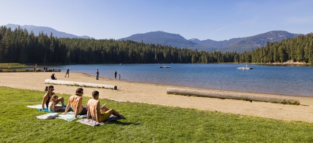 Visitors relaxing on the beach at Lost Lake in Whistler