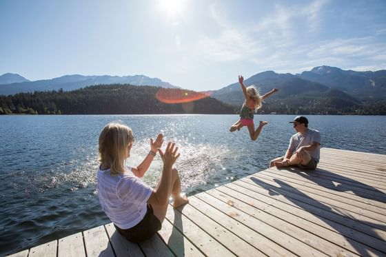 A family sitting on a dock & enjoying the serene view near Blackcomb Springs Suites