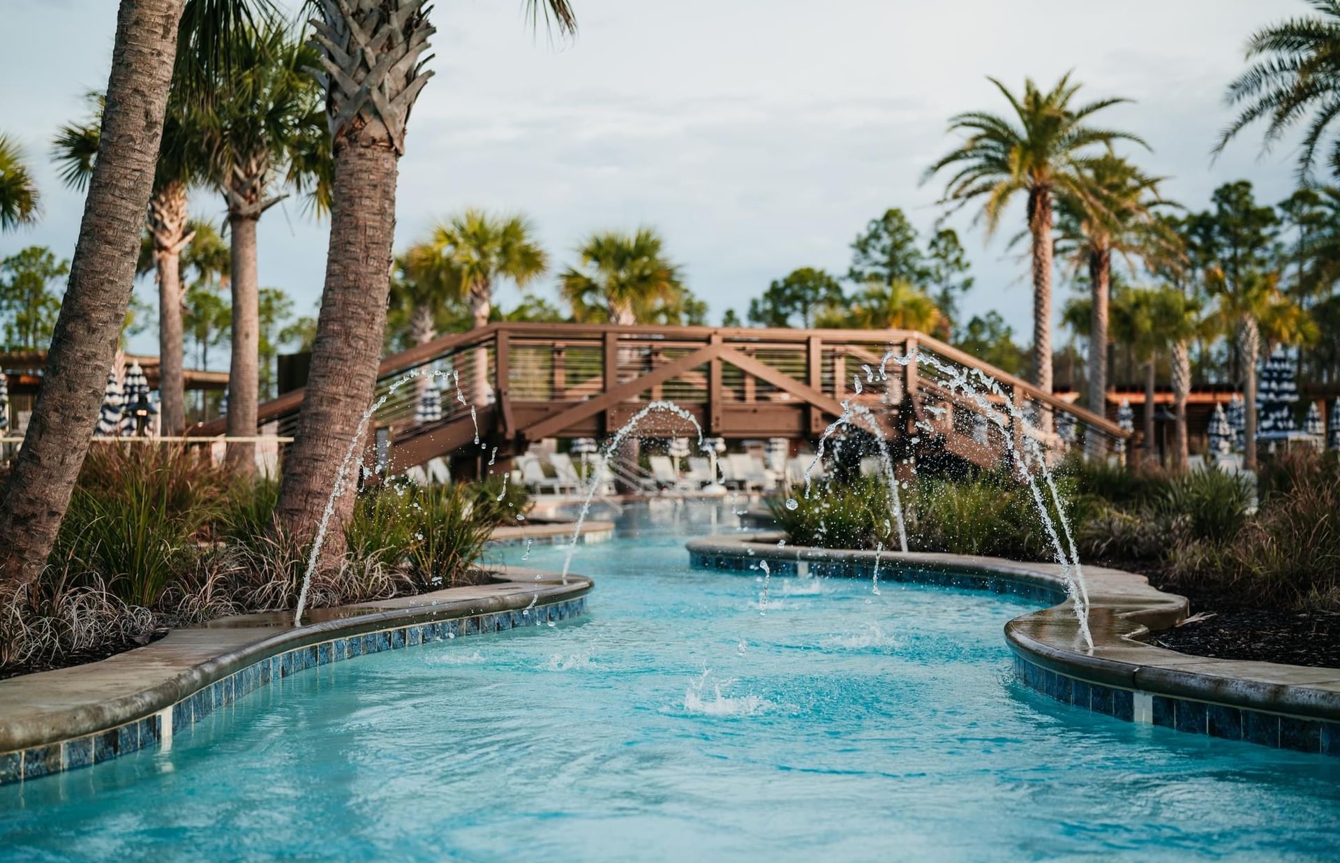 The lazy river with water fountain features and walkover boardwalk at Camp Creek Inn