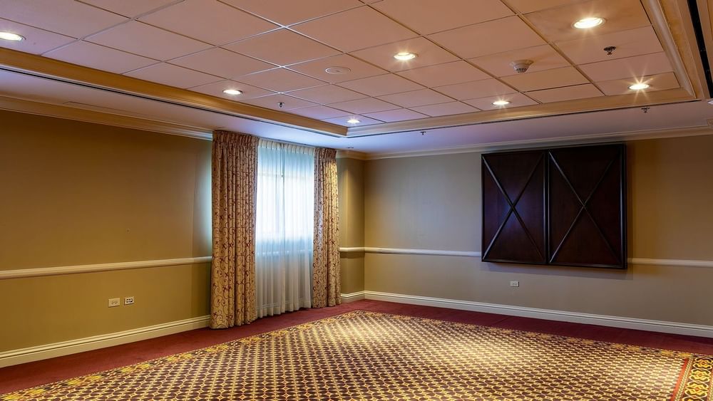 Empty event room with patterned carpet by tan walls under a grid ceiling in Capitol I/II/III at Warwick Denver