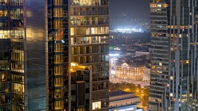 Nighttime cityscape with illuminated office buildings and distant lights near Polonia Palace Hotel
