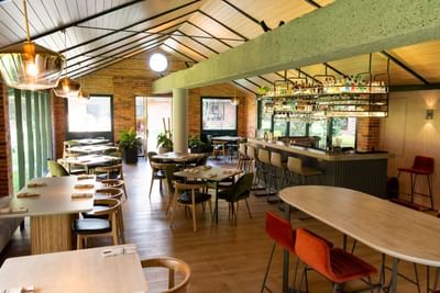 Dining area and bar with vaulted ceiling and exposed beams at La Tiendita Steak House in Habitel Prime Hotel