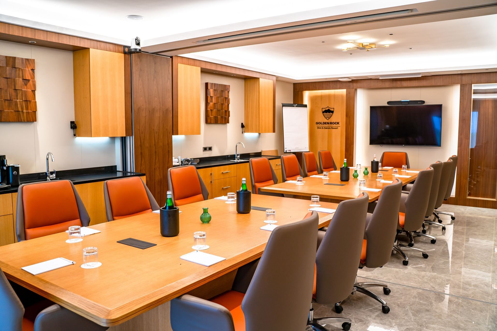 St. Kitts Boardroom with a wooden executive table and orange chairs near a large television display at Golden Rock Resort