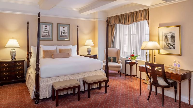 Comfy bed with side tables and working table in Suite of the Stars at Warwick New York