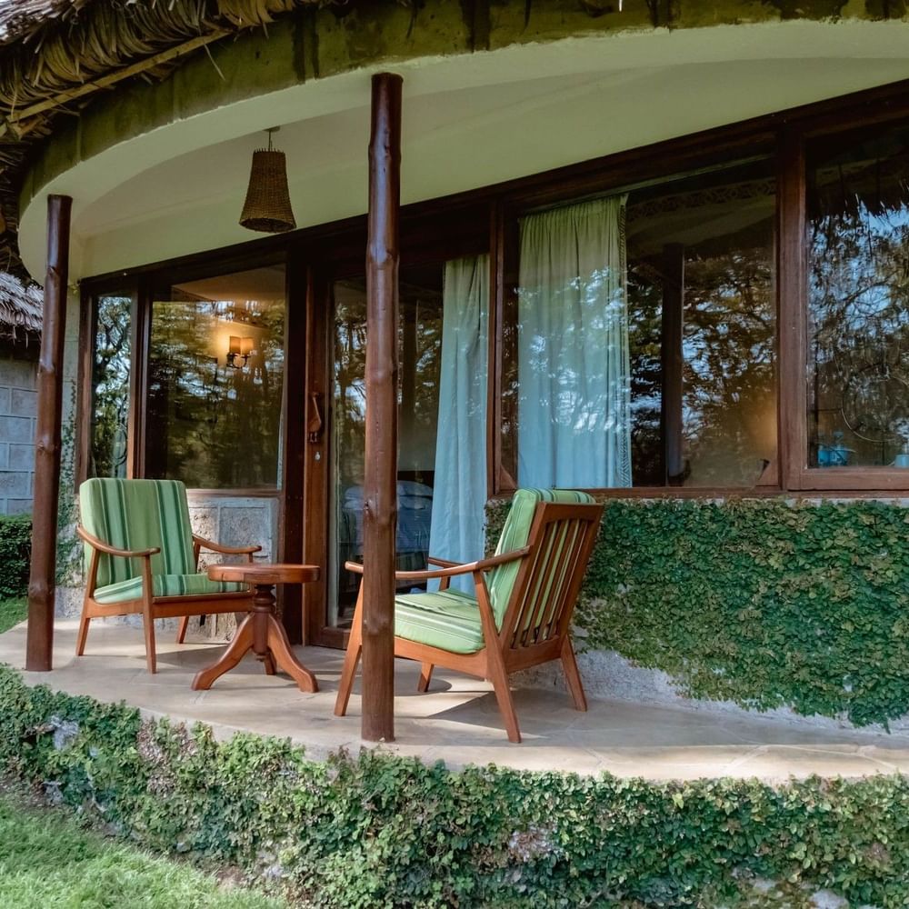 Outdoor seating with two green chairs and a table at Arusha Serena Hotel in Arusha.