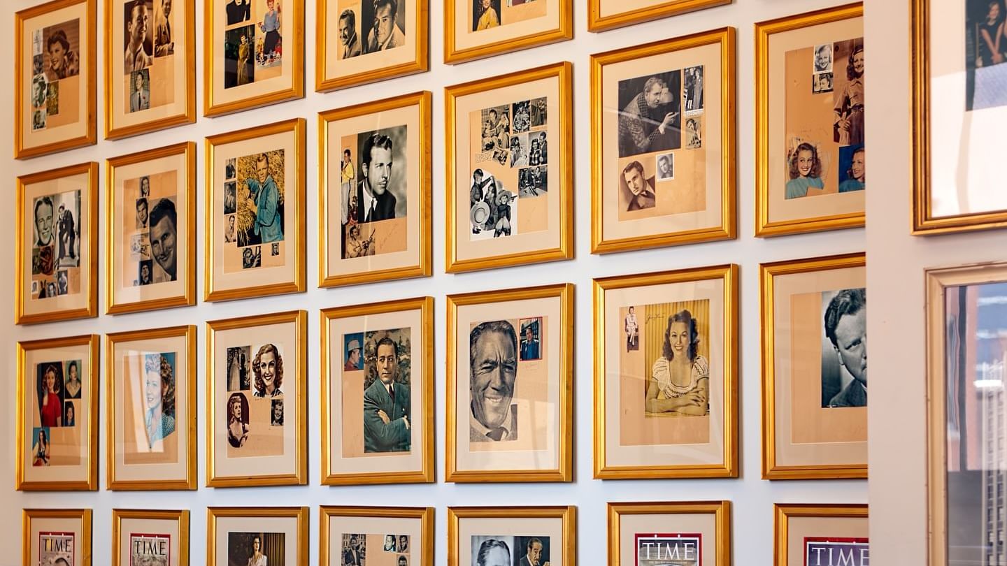 Wall full of framed pictures and a meeting table at The Mayo Hotel in Tulsa.