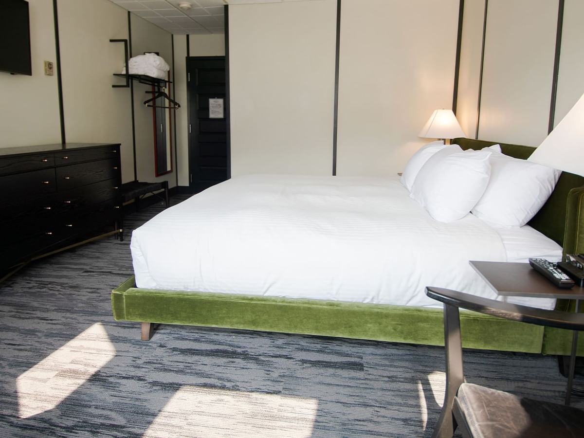 Hotel room with king bed, lamp, night stand, premium coffee, TV, chair, and window