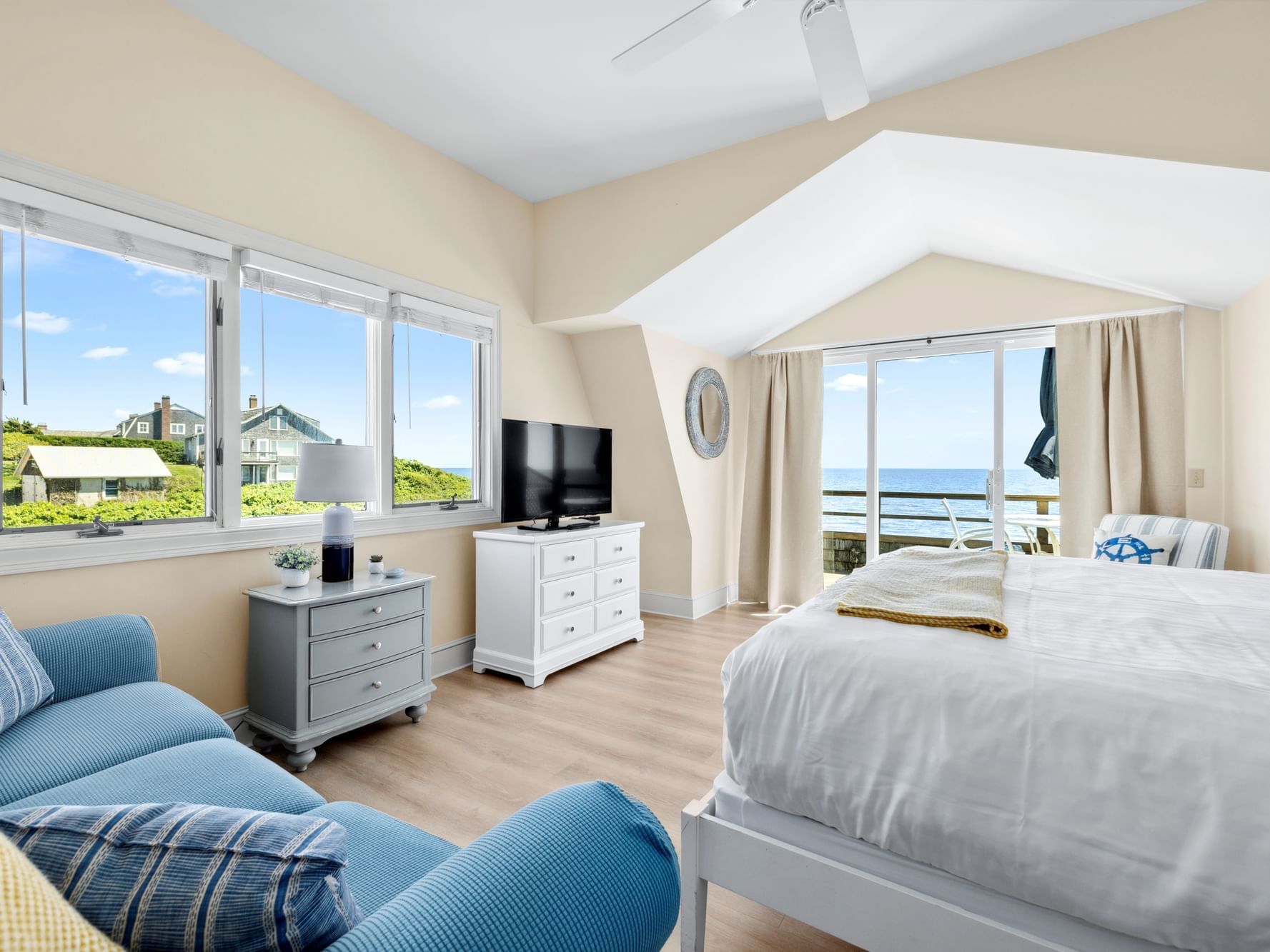 King bed, views of water, and TV on credenza in Suntide Oceanfront King at Chatham Tides Resort