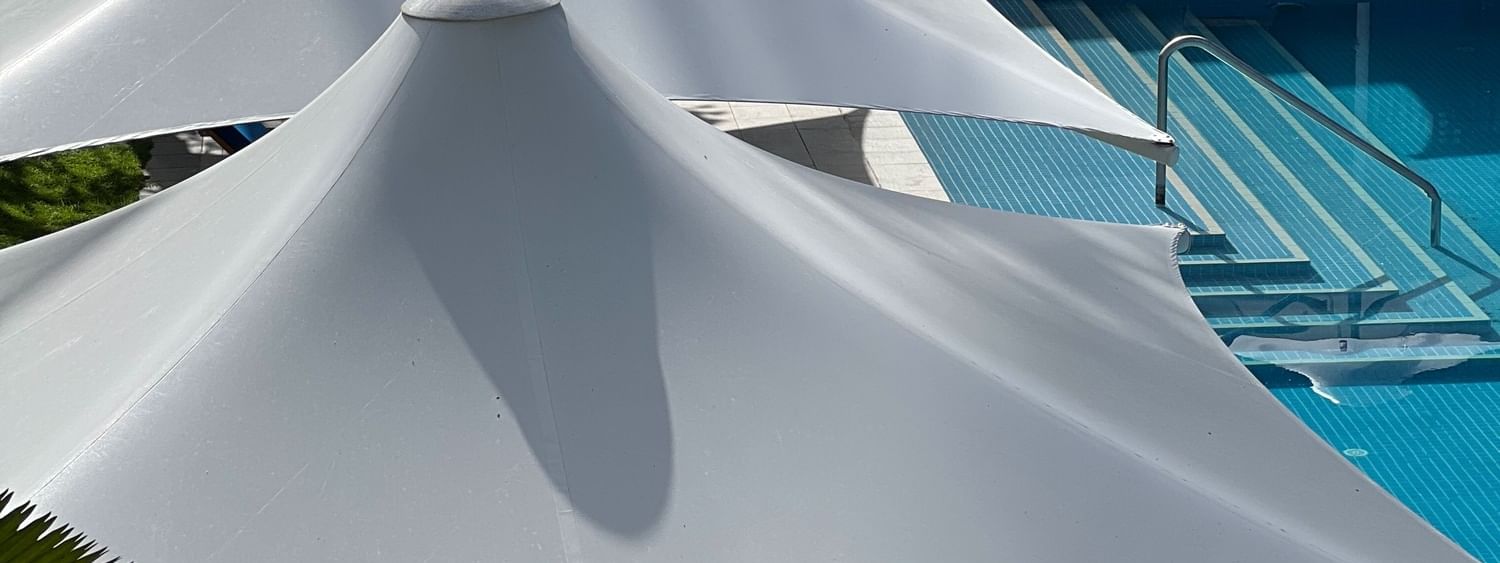 White canopy umbrellas over pool lounge chairs at Warwick Fiji Resort and Spa in Korolevu
