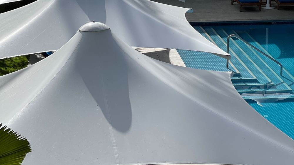 White canopy umbrellas over pool lounge chairs at Warwick Fiji Resort and Spa in Korolevu.