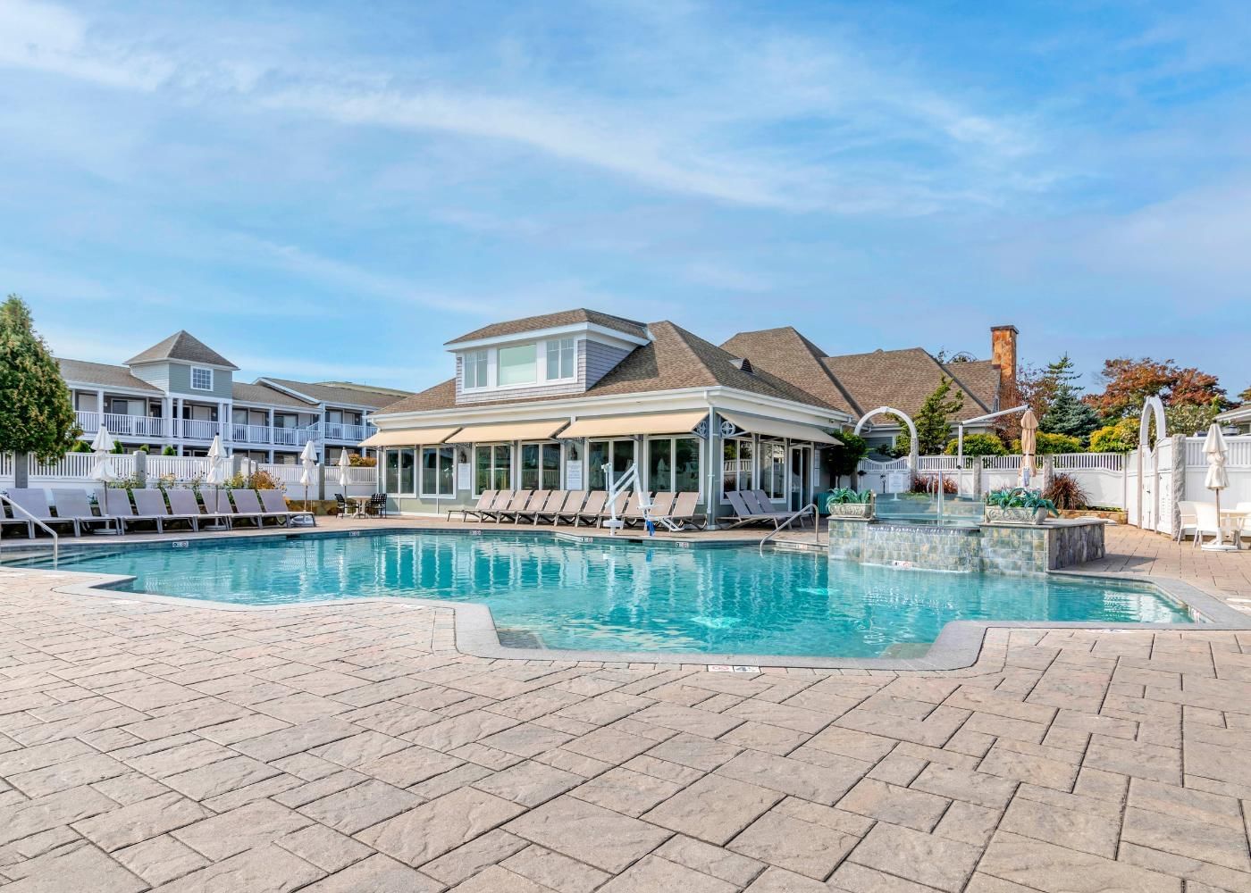 A large pool area with a pavilion, lounge chairs, and a water feature.
