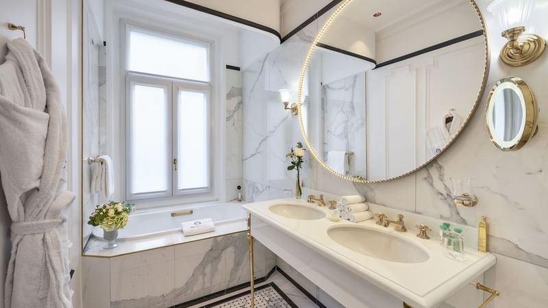 Modern bathroom featuring marble walls, a bathtub, towels on a rack in Duke of Westminster Suite at Hôtel Westminster - Paris