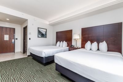 Nightstand by the cozy beds in Queen Resort View Room with patterned carpet at Off Shore Resort