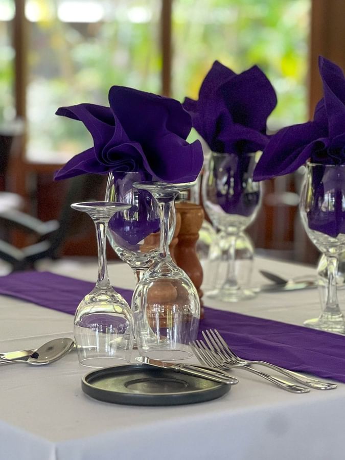 Elegant table setting with purple napkins and wine glasses at Talei Restaurant in Korolevu at The Naviti Resort Fiji