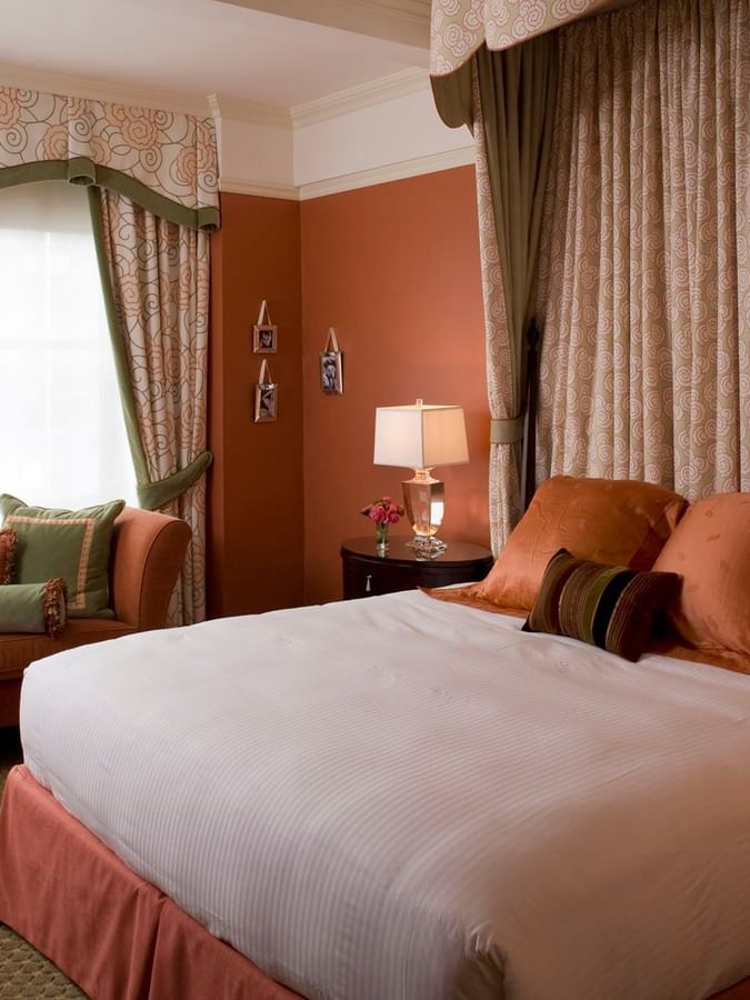 Peach-toned bedroom featuring a canopy bed and a cozy window seating lounge in Hollywood Suite at Warwick New York