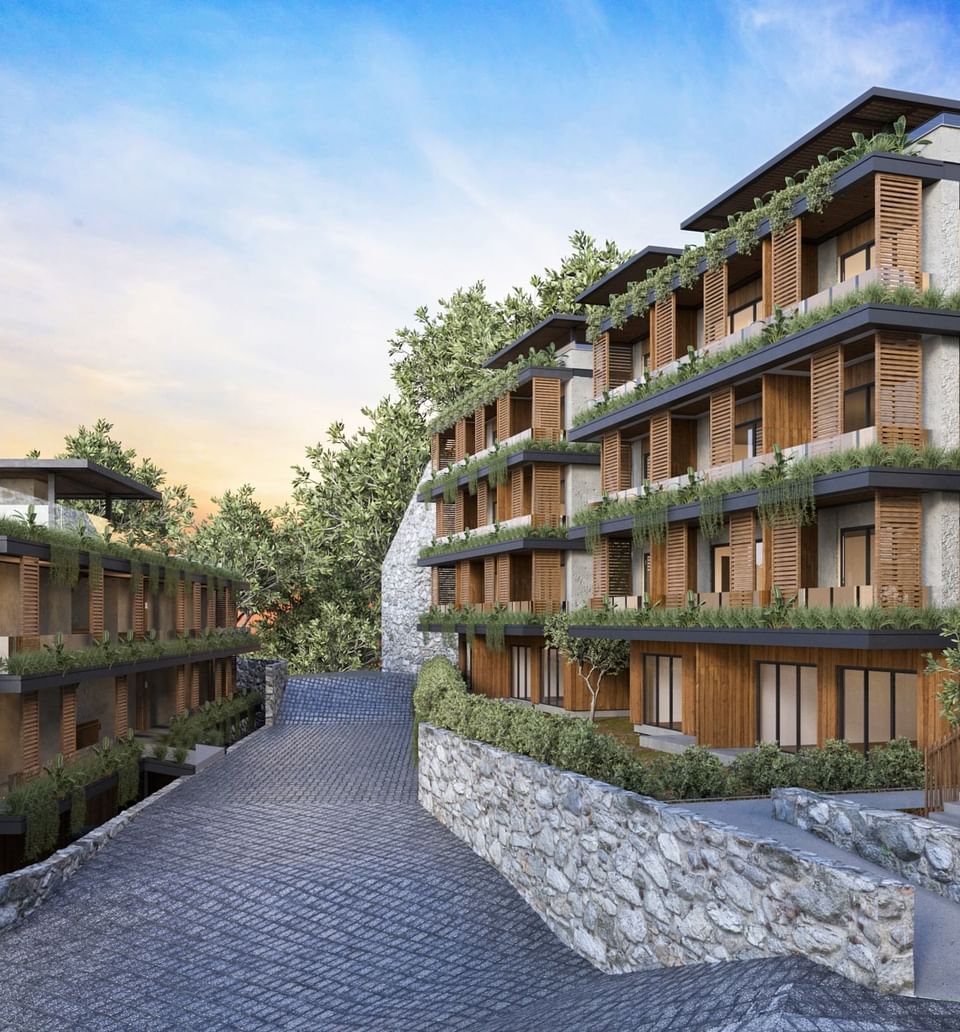 Beautifully terraced BlueZone Residence buildings at A'ila Residences, with lush greenery and stone walls