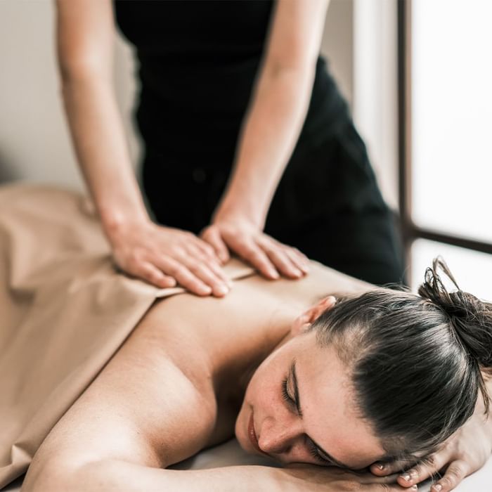 Lady having a back massage in Acquapura Spa at Falkensteiner Hotel Antholz