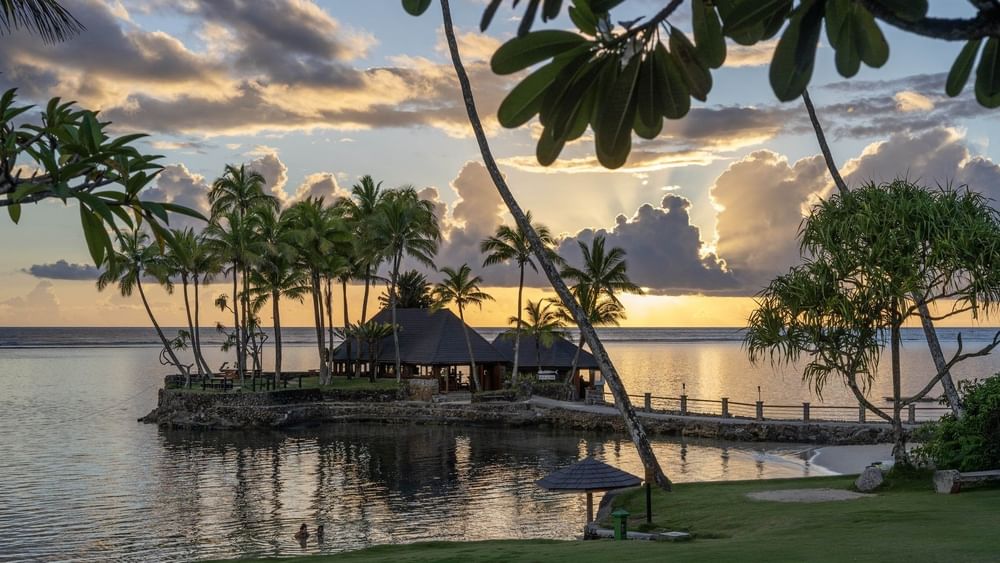 Wicked Walu by a stone walkway under a golden sunset near palm trees at Warwick Fiji Resort and Spa