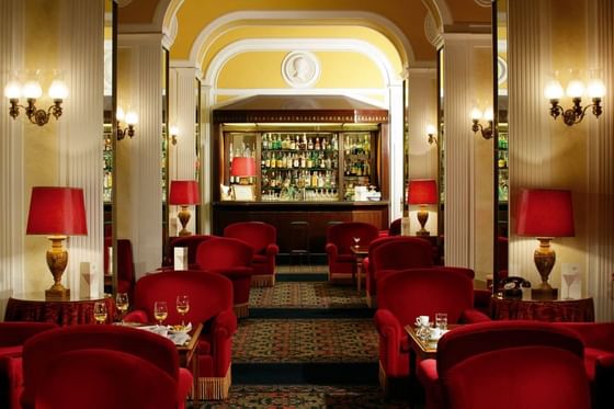 Hotel lobby with red chairs & bar at Bettoja Hotel Mediterraneo