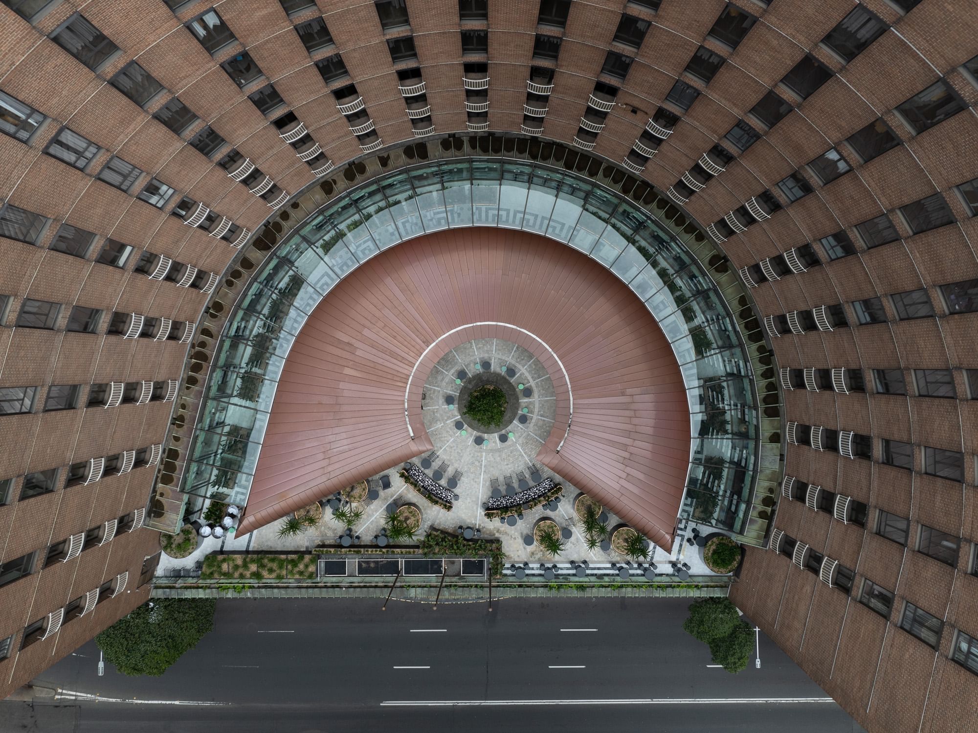 A high-angle view of a spiral-shaped building with multiple floors and a road below.