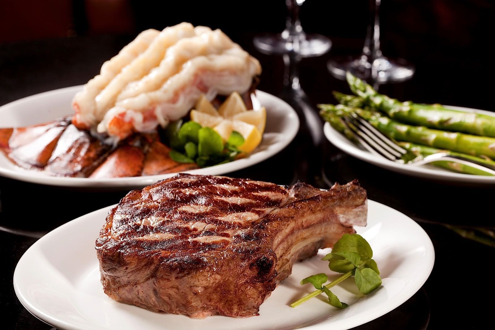 Grilled ribeye steak, lobster & Asparagus served on a table, enjoy hotel corporate rates at The St. Regis Hotel Vancouver