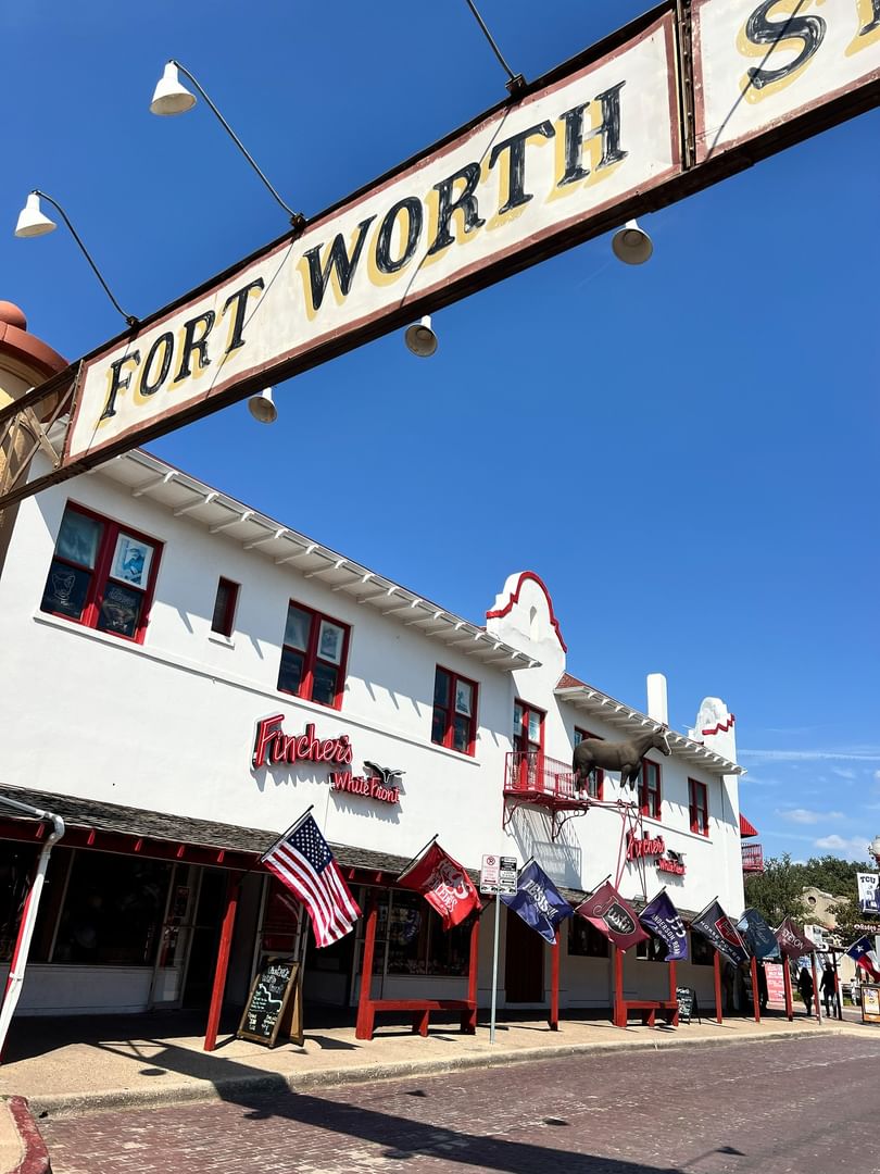 Historic Fort Worth Stockyardsby the Fort  Worth sign under a blue sky near Warwick Melrose Dallas
