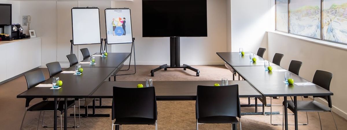 U-shape table set up facing the large screen by the window in Banksia at Novotel Sydney International Airport 