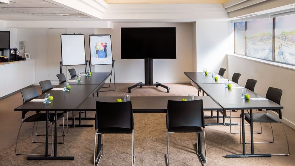 U-shape table set up facing the large screen by the window in Banksia at Novotel Sydney International Airport 